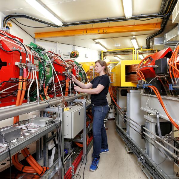 Woman standing next to accelerator transport line