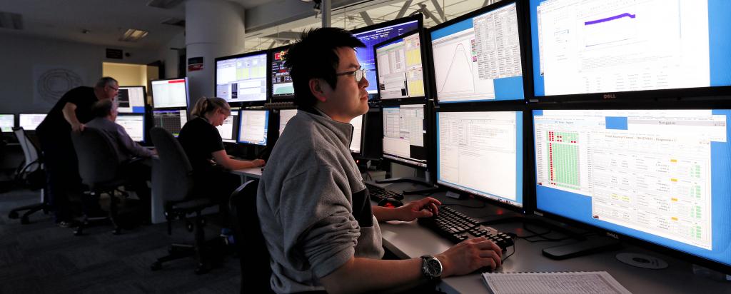 Control room, showing people looking at many computer screens