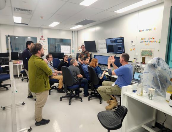 Staff gathered around banks of computers, working to bring beam through MX3