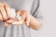 closeup woman hand holding medicine bottle taking overdose pills